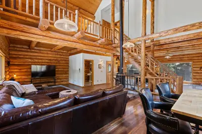 a living room with a leather couch and a television at Tahoe Wanderer - 3 BR Luxury Log Cabin with Additional Loft, Private Hot Tub in Tahoe Vista