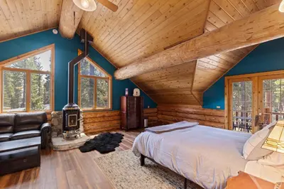 a bedroom with a large bed and a fireplace at Tahoe Wanderer - 3 BR Luxury Log Cabin with Additional Loft, Private Hot Tub in Tahoe Vista