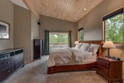 a bedroom with a large bed and a window at Treetop at Tahoe Donner - Pet Friendly 4BR w Gym and Pool Access in Truckee
