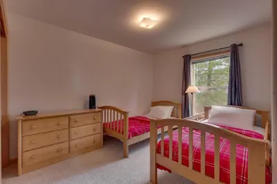 a bedroom with two beds and a dresser and a window at Treetop at Tahoe Donner - Pet Friendly 4BR w Gym and Pool Access in Truckee