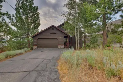 a house with a garage on the side of a road at Treetop at Tahoe Donner - Pet Friendly 4BR w Gym and Pool Access in Truckee