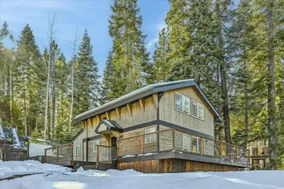 a log cabin in the woods in the snow at Granlibakken Getaway by Tahoe Getaways - West Shore Retreat-Central Location-Hot Tub-Dog Considered-Near Skiing in Tahoe City
