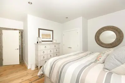 a bedroom with a bed with a mirror and a dresser at First Light Farmhouse- Hot Tub- Gourmet Kitchen- Premier Neighborhood in Truckee