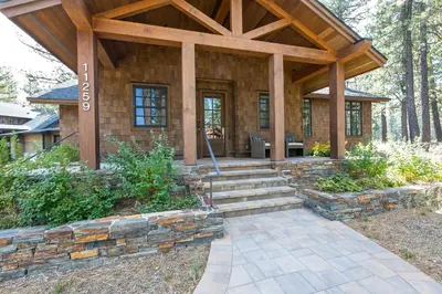 a house with a stone retaining wall and a wooden roof at First Light Farmhouse- Hot Tub- Gourmet Kitchen- Premier Neighborhood in Truckee