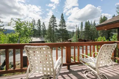 two white chairs sitting on a deck with trees at Victory Place at Palisades - Stunning 5 BR with Private Hot Tub and Pool Table in Olympic Valley