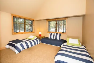 two beds in a room with two windows at Truckee Treasure at Grays Crossing by Tahoe Getaways - Relaxing Home w Private Hot Tub, Dogs Welcome! in Truckee