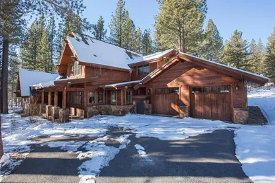 a log cabin with snow on the ground at Truckee Treasure at Grays Crossing by Tahoe Getaways - Relaxing Home w Private Hot Tub, Dogs Welcome! in Truckee