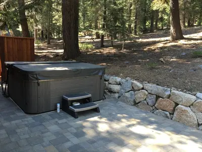 a hot tub sitting next to a stone wall at St Bernard at Tahoe Donner Remodeled 3BR - Private Hot Tub and Gym and Pool Access in Truckee