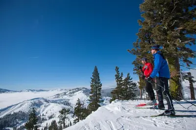 two people on skis on top of a mountain at St Bernard at Tahoe Donner Remodeled 3BR - Private Hot Tub and Gym and Pool Access in Truckee
