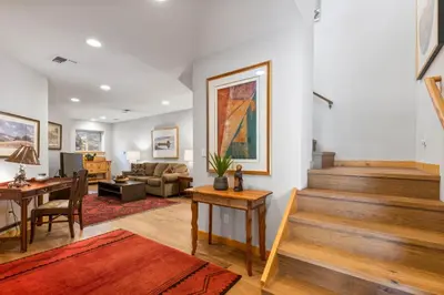 a living room with stairs and a table and a couch at Trailside - Alpine Meadows 6 Bedroom with Private Hot tub in Alpine Meadows