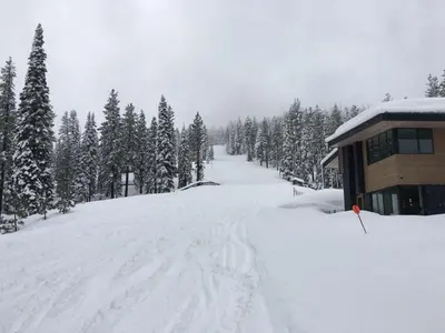 a snow covered road next to a ski lodge at Stellar Ski-in Ski-out Townhouse 8 - Luxury 3 BR w Private Hot Tub and Gym and Pool Access in Truckee