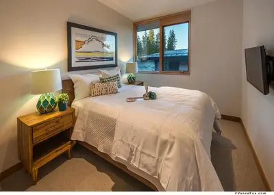 a bedroom with a bed with a lamp and a window at Stellar Ski-in Ski-out Townhouse 8 - Luxury 3 BR w Private Hot Tub and Gym and Pool Access in Truckee