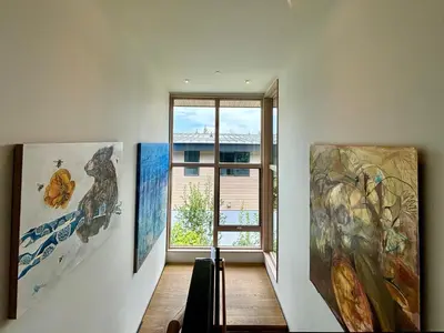 a hallway with paintings on the wall and a window at Stellar Ski-in Ski-out Townhouse 8 - Luxury 3 BR w Private Hot Tub and Gym and Pool Access in Truckee