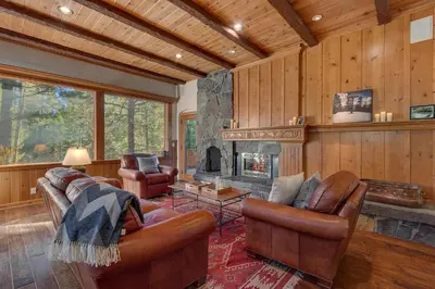 a living room with leather furniture and a fireplace at Swiss Chalet-Palisades, 6 BR, Hot Tub, Pets Ok, Ski Shuttle! in Olympic Valley