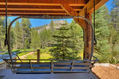 a swing on a porch with a view of a mountain at Bullshead Lodge- Luxury Estate, 4 Acres on River, Hot Tub, Minutes from the Slopes! in Olympic Valley
