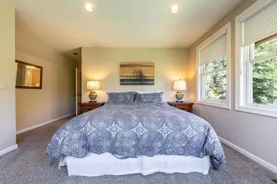 a bedroom with a blue bed with two windows at Eagles Nest by Tahoe Getaways - Pet Friendly with Hot Tub, Pool Table & Shuttle to Slopes in Olympic Valley