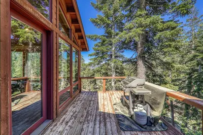 a grill on the deck of a tree house at Eagles Nest by Tahoe Getaways - Pet Friendly with Hot Tub, Pool Table & Shuttle to Slopes in Olympic Valley