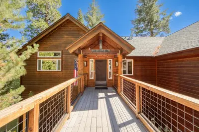 a cabin with a wooden walkway to the front door at Fawn View by Tahoe Getaways - Spacious 5 BR w Pool Table-Short Drive to Northstar in Tahoe Vista
