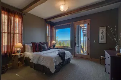 a bedroom with a bed and a large window at Grand Vista Lodge by Tahoe Getaways - 5 BR with Stunning Views, Pool Table, Private Hot Tub & HOA Pool! in Truckee
