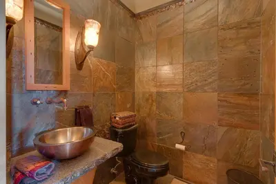 a bathroom with a copper sink and a toilet at Grand Vista Lodge by Tahoe Getaways - 5 BR with Stunning Views, Pool Table, Private Hot Tub & HOA Pool! in Truckee