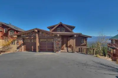 a large house with a garage and a driveway at Grand Vista Lodge by Tahoe Getaways - 5 BR with Stunning Views, Pool Table, Private Hot Tub & HOA Pool! in Truckee