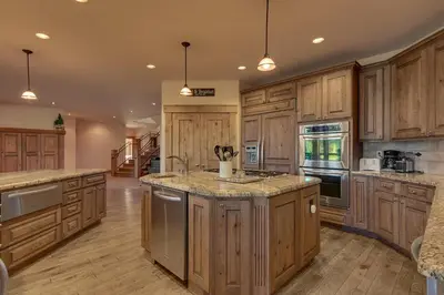 a large kitchen with wooden cabinets and granite counter tops at Highland Estate at Old Greenwood - Large, Luxury, Private Hot Tub & Amenity Access in Truckee