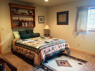 a bedroom with a bed and a book shelf at Sierra Crest at Palisades Tahoe - Secluded Luxury 5BR 5 BA w Wood Fireplace in Olympic Valley