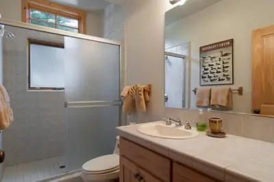 a bathroom with a sink and a toilet and a shower at Sierra Crest at Palisades Tahoe - Secluded Luxury 5BR 5 BA w Wood Fireplace in Olympic Valley