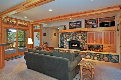 a living room with a couch and a fireplace at Sierra Crest at Palisades Tahoe - Secluded Luxury 5BR 5 BA w Wood Fireplace in Olympic Valley