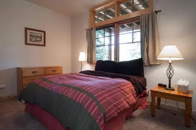 a bedroom with a large bed and a window at Sierra Crest at Palisades Tahoe - Secluded Luxury 5BR 5 BA w Wood Fireplace in Olympic Valley