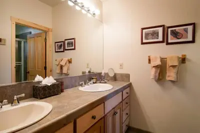 a bathroom with two sinks and a large mirror at Sierra Crest at Palisades Tahoe - Secluded Luxury 5BR 5 BA w Wood Fireplace in Olympic Valley