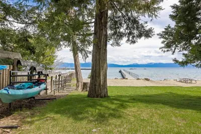 a boat on the grass next to a beach at Starry Skies on the West Shore, Private Beach, Fireplace, Pet Friendly, Close to Ski Resorts in Tahoe City