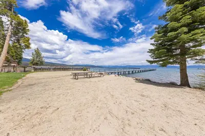 a picnic table on a beach next to a pier at Starry Skies on the West Shore, Private Beach, Fireplace, Pet Friendly, Close to Ski Resorts in Tahoe City