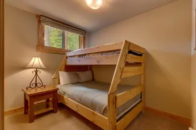 a bedroom with a bunk bed and a desk at Summit Solitude at Palisade Tahoe - Charming 5BR w Foosball & Shuffleboard Table & Pet Friendly in Olympic Valley