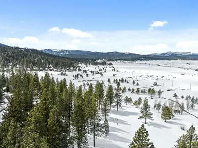 an aerial view of a snow covered field with trees at 4 Bedroom Home at 392 Skidder Trail home in Truckee