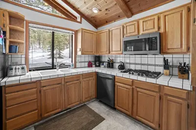 a kitchen with wooden cabinets and a stove at 4 Bedroom Home at 392 Skidder Trail home in Truckee