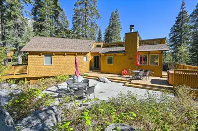 a log home with a deck and patio at Alpine Adventure- Shuttle to Ski Lifts- Hot Tub- Pet Friendly in Alpine Meadows