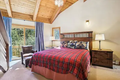 a bedroom with a bed and a chair and a window at Alpine Adventure- Shuttle to Ski Lifts- Hot Tub- Pet Friendly in Alpine Meadows