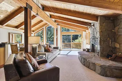 a living room with couches and a stone fireplace at Alpine Adventure- Shuttle to Ski Lifts- Hot Tub- Pet Friendly in Alpine Meadows