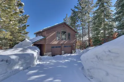 a house is covered in snow with trees at Above the Pines - Hot Tub- Pet Friendly -Gym and Pool Access in Truckee