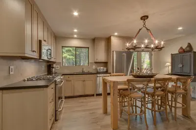a kitchen with a table and chairs and a chandelier at Antler House- Quiet, Charming Cabin w Cozy Fireplace, Close to Skiing in Tahoe City