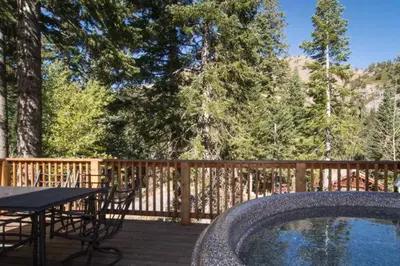 a wooden deck with a table and a swimming pool at Alpine Darling- Hot Tub- Pet Friendly- 3 Minute Drive to Palisades Tahoe in Alpine Meadows