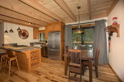 a kitchen with wooden floors and a table with chairs at Away on Allenby by Tahoe Getaways - 3BR, Dog Ok, Close to Northstar! in Tahoe Vista