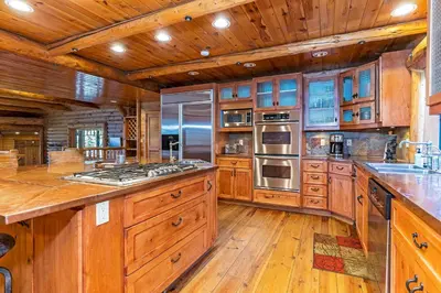 a large kitchen with wooden cabinets and wooden floors at 1138 Lakeshore - One-of-a-kind Lakeshore Boulevard log cabin in Incline Village