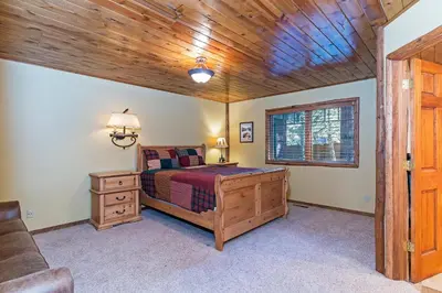 a bedroom with a bed and a wooden ceiling at 1138 Lakeshore - One-of-a-kind Lakeshore Boulevard log cabin in Incline Village