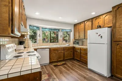 a kitchen with a white refrigerator and wooden cabinets at 1 Sky Lake - walk to town in Incline Village