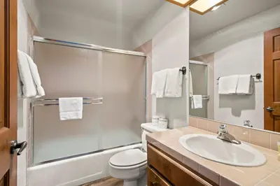 a bathroom with a sink and a toilet and a mirror at 1 Sky Lake - walk to town in Incline Village