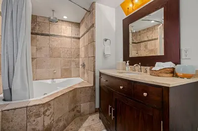 a bathroom with a tub and a sink and a mirror at Magnificent 2-bedroom, 2-bath lakefront complex in Incline Village
