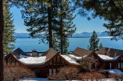 a cabin with snow on the roofs and a view of the water at Magnificent 2-bedroom, 2-bath lakefront complex in Incline Village