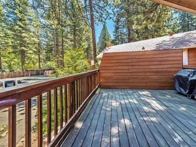 a wooden deck with a fence and trees at Perfect location walk to town and nature in Incline Village